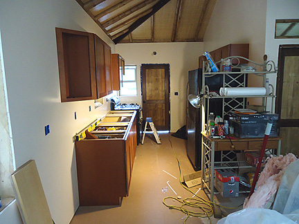 inside bamboo house kitchen with new dark wood cabinets and black refrigerator