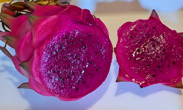 Red Dragon Fruit cut in half showing black seeds