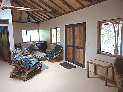 inside house peach color with a few chairs windows and bamboo doors